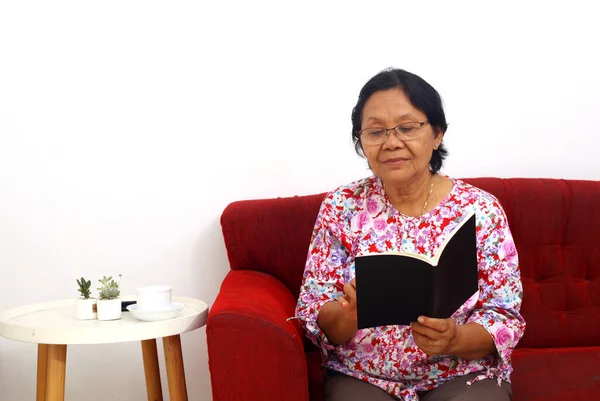 Ηλικιωμένη Ασιάτισσα Που Κάθεται Διαβάζοντας Ένα Βιβλίο Απομονωμένο Λευκό Φόντο — Φωτογραφία Αρχείου