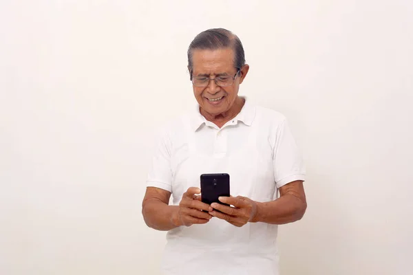 Happy Elderly Asian Man Standing While Holding His Cell Phone — Φωτογραφία Αρχείου