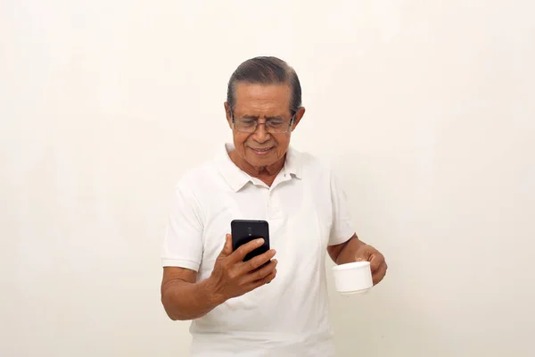 Boldog Idős Ázsiai Férfi Áll Miközben Mobilját Csészéjét Fogja Fehér — Stock Fotó