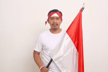 Asyalı adam elinde Endonezya bayrağı tutarken ayakta duruyor. Bağımsızlık Günü konsepti. Beyazda izole edilmiş