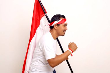 Asian man with running gesture while holding indonesian flag. Independence day concept.