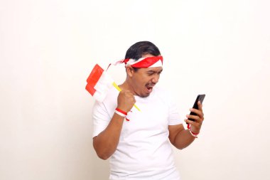 Cep telefonu ve Endonezya bayrağı taşıyan mutlu Endonezyalı adam. Bağımsızlık Günü kavramı