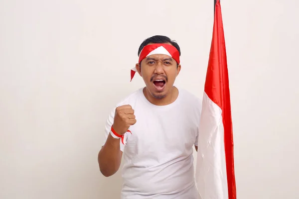 Passionate Asian Man Standing Clenched Hand While Holding Indonesian Flag — Stockfoto