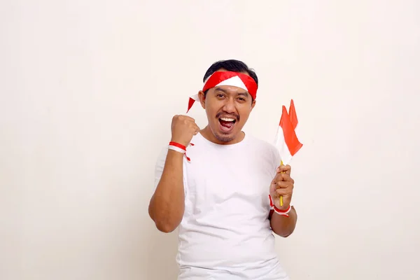 Passionate Asian Man Standing Clenched Hand While Holding Indonesian Flag — ストック写真