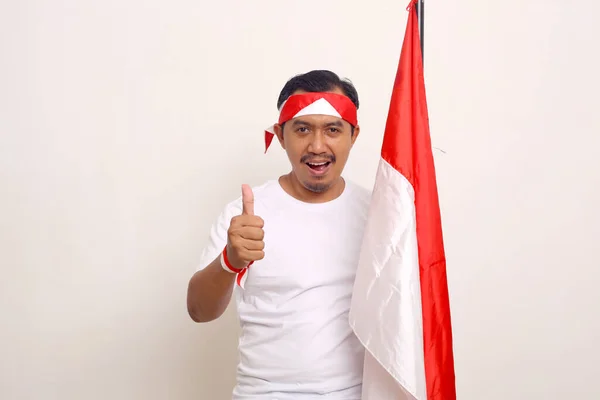 Asian Man Standing While Showing Thumbs Holding Indonesian Flag Isolated — Stock Fotó
