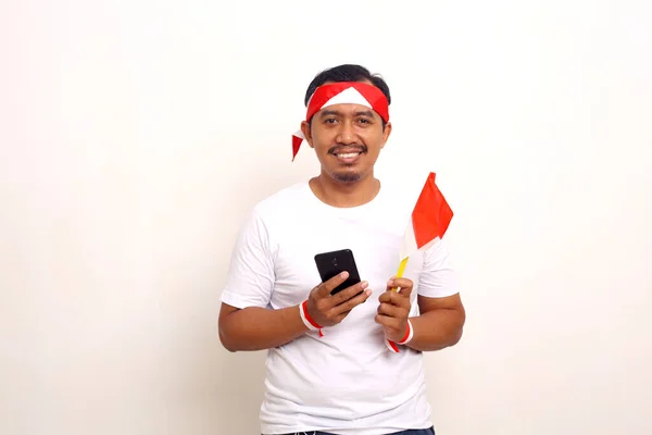 Happy Asian Man Standing While Holding Cellphone Indonesian Flag Isolated — 图库照片