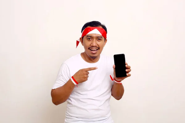 Asian Man Standing While Pointing Blank Cell Phone Screen Indonesian — ストック写真