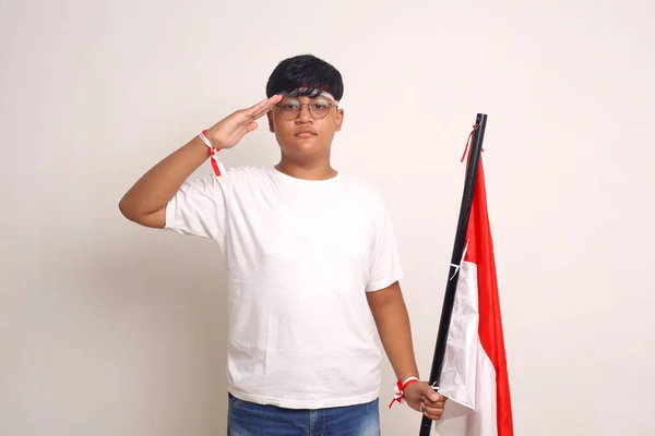 Asian Boy Holding Indonesian Flag While Showing Respect Salute Gesture — Foto de Stock