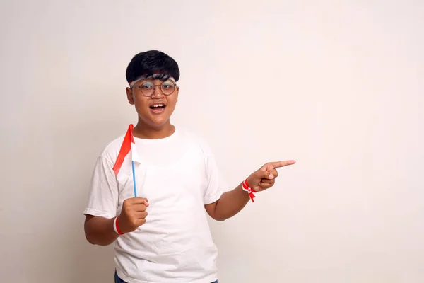 Asian Boy Holding Indonesian Flag While Pointing Sideways Isolated White — Stock Photo, Image