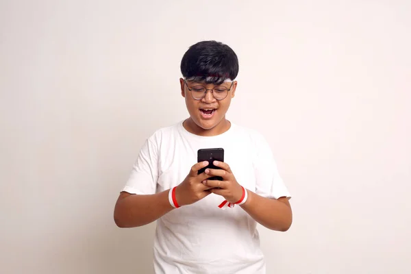 Gelukkige Aziatische Jongen Die Staat Terwijl Hij Een Mobieltje Vasthoudt — Stockfoto