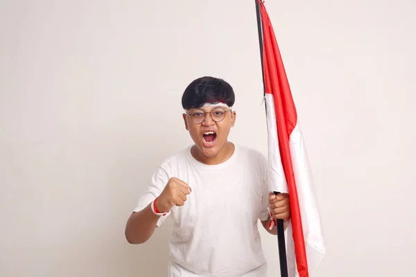 Asian Boy Holding Indonesian Flag While Clenching His Hand Screaming — Stockfoto