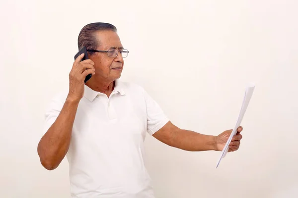 Elderly Asian Man Standing While Talking Phone Holding Papers Isolated — Φωτογραφία Αρχείου