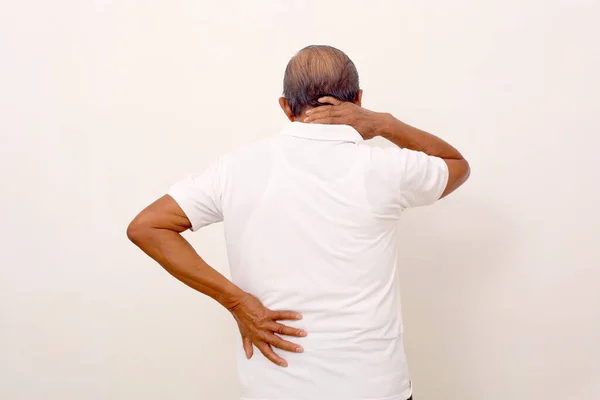 Back view of tired asian old man suffering from back pain and neck pain. Isolated on white