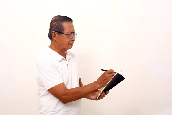Elderly Asian Man Standing While Writing Book Isolated White Background — Stock Fotó