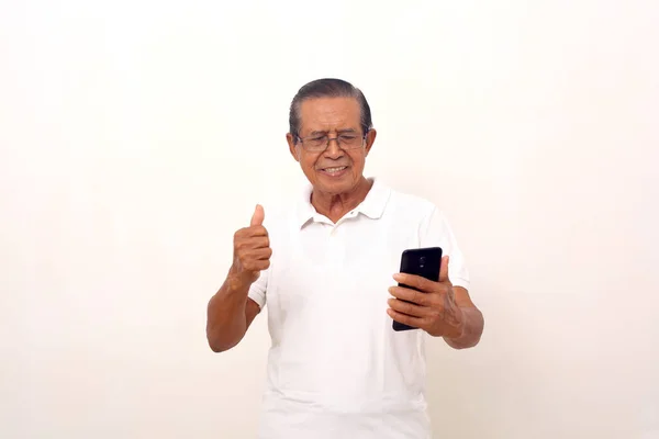 Happy Asian Old Man Standing While Holding Cell Phone Clenching — стоковое фото
