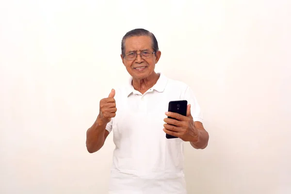 Happy Asian Old Man Standing While Holding Cell Phone Clenching — Fotografia de Stock