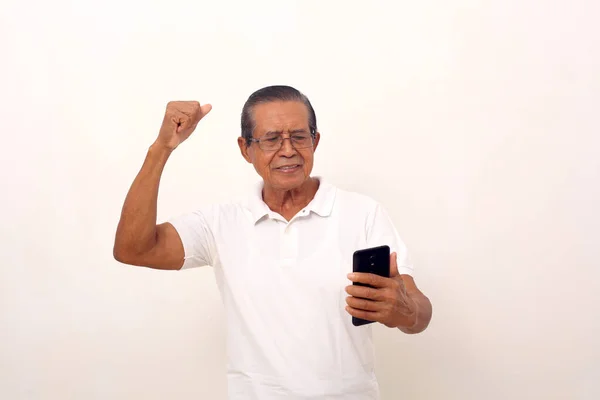 Happy Asian Old Man Standing While Holding Cell Phone Clenching — стоковое фото
