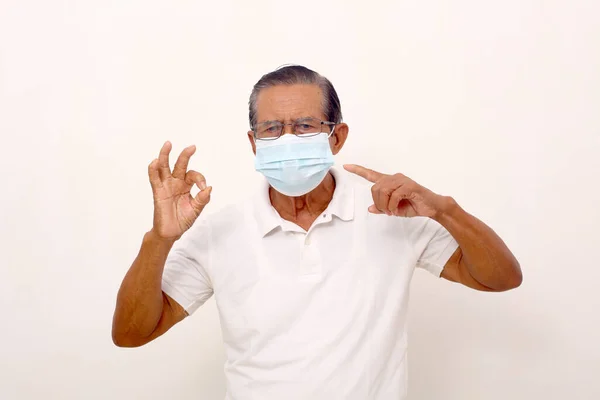 Elderly Asian Man Wearing Face Mask Standing While Pointing Mask — Zdjęcie stockowe