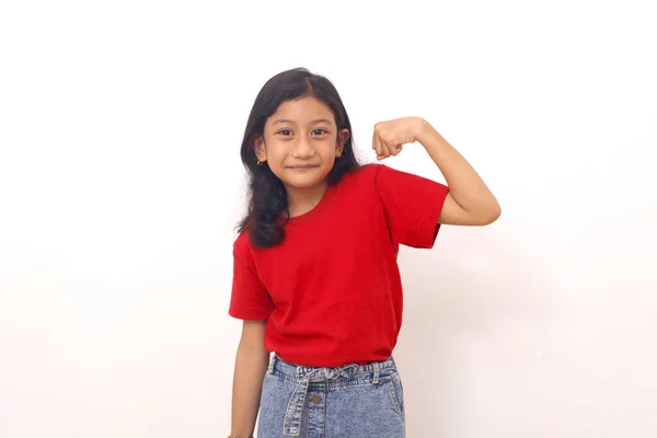 Happy Asian Little Girl Standing While Showing Strong Hand Gesture — Zdjęcie stockowe