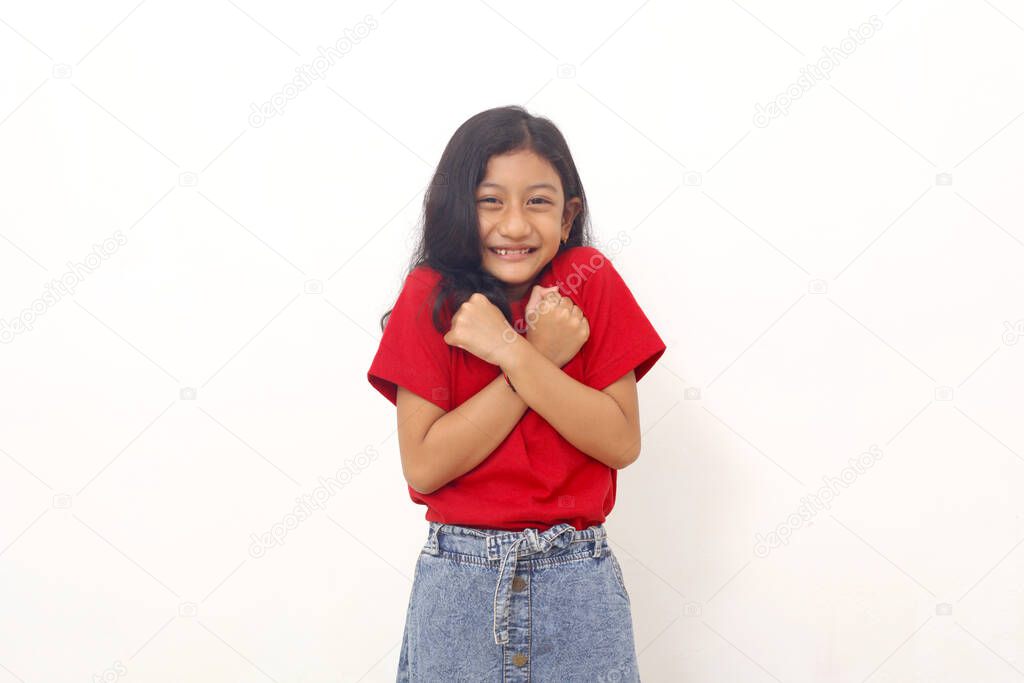 Asian little girl standing while feeling cold and shivering. Isolated on white background