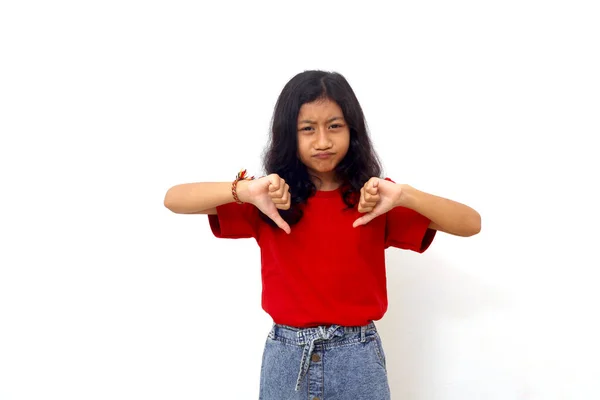 Unhappy Asian Little Girl Standing While Showing Thumbs Isolated White — Stock fotografie