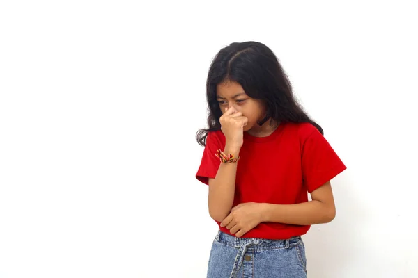 Tired Asian Little Girl Standing While Holding Her Nose Isolated — Stockfoto