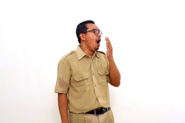 Tired Indonesian government employees standing while yawning. He feels sleepy. Isolated on white