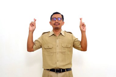 Indonesian government employees standing while gesturing finger crossed smiling with hope and eyes closed