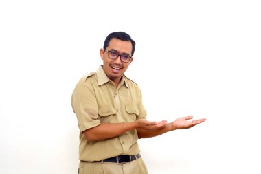 Happy Indonesian government employees standing while presenting sideways on blank space