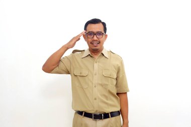 Happy Indonesian government employees standing and looking at the camera with salute gesture