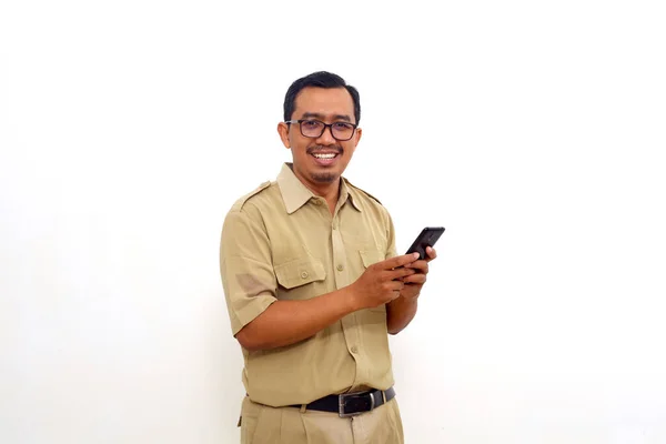 Happy Indonesian Government Employees Standing While Holding Cell Phone Isolated — Stok fotoğraf