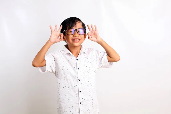 Boldog Ázsiai Fiú Áll Kézmozdulattal Miközben Becsukja Szemét Fehér Alapon — Stock Fotó