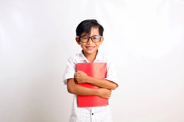 本を持ちながら立ち上がる幸せなアジア系の少年 白地に隔離された — ストック写真