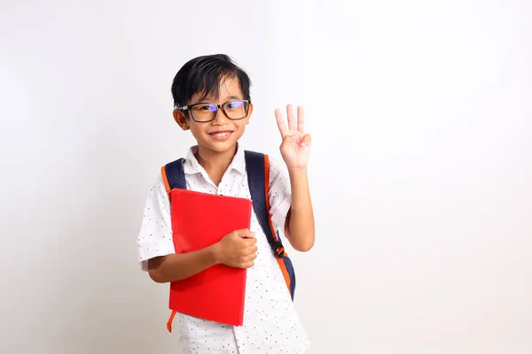 Happy Asian Schoolboy Standing While Showing Three Fingers Carrying Book — Stock Photo, Image