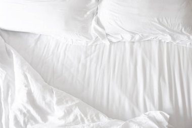 Yatak odasında fotokopi alanı olan yatak ve beyaz yastıklar.