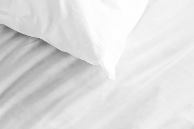 Yatak odasında fotokopi alanı olan yatak ve beyaz yastıklar.