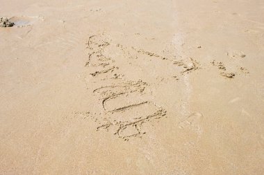 Güzel kumsalda turistlerin karalamaları var.