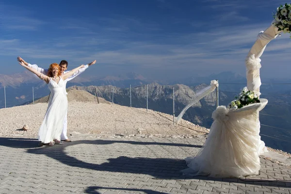 Novomanželé představují poblíž svatební oblouk — Stock fotografie