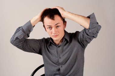 Elleri başının üstünde genç bir adam.