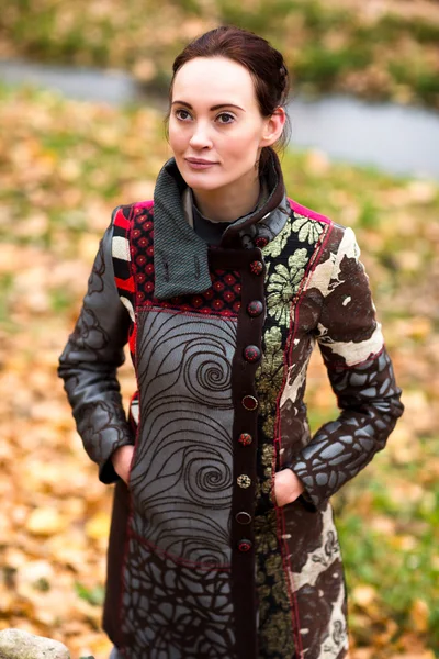 Beautiful lady in design coat poses in autumn — Stock Photo, Image