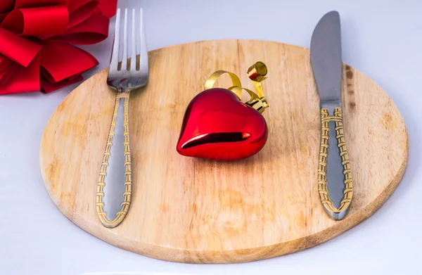 Beautiful toy heart lies on a chopping board — Stock Photo, Image