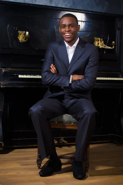 Siyah adamın yanında piyano — Stok fotoğraf
