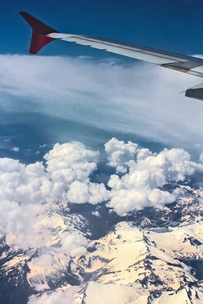 Kar kaplı dağlar ve bulutlar, airpane wing ile Üstten Görünüm — Stok fotoğraf