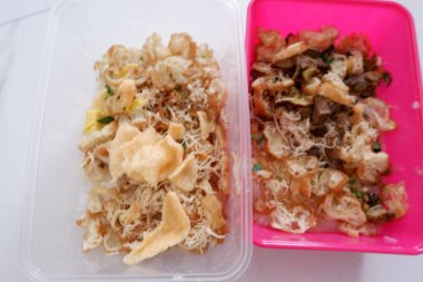 Pembe ve beyaz yiyecek kabında tavuk lapası ve karides.