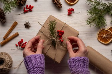 Kadın eli el yapımı el yapımı el yapımı el işi Noel hediyesi yapıyor. Beyaz ahşap masa üzerinde makas, üst manzara.