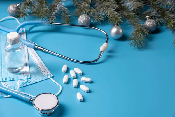 Świąteczne dekoracje medyczne stetoskopem i maskami na niebieskim tle. Koncepcja medyczna. Kopiuj miejsce na tekst — Zdjęcie stockowe