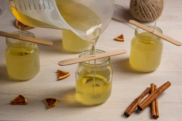 Set for crafting candle on wooden background. Pouring soy eax into glass. Eco soy wax on white table. DIY candle. Hobby concept. — Stock Photo, Image