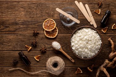 Ahşap arka planda mum yapımı için ayarlandı. Beyaz masada eko soya cilası. Mumu söndür. Hobi konsepti.