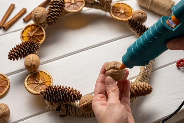 Corona de componentes naturales. Mujeres manos haciendo eco natural decoración de Navidad. —  Fotos de Stock
