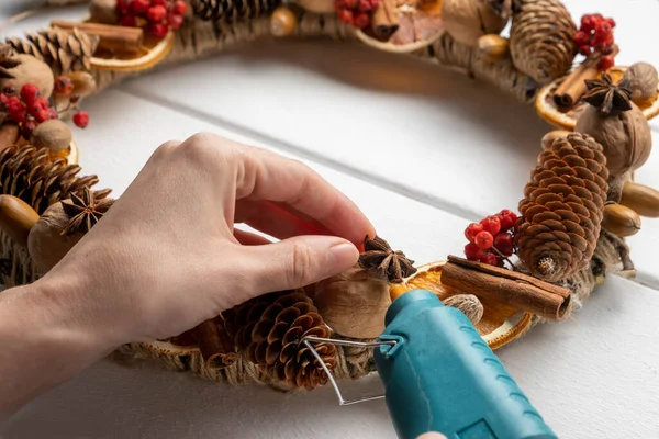 Corona de componentes naturales. Mujeres manos haciendo eco natural decoración de Navidad. Imágenes De Stock Sin Royalties Gratis